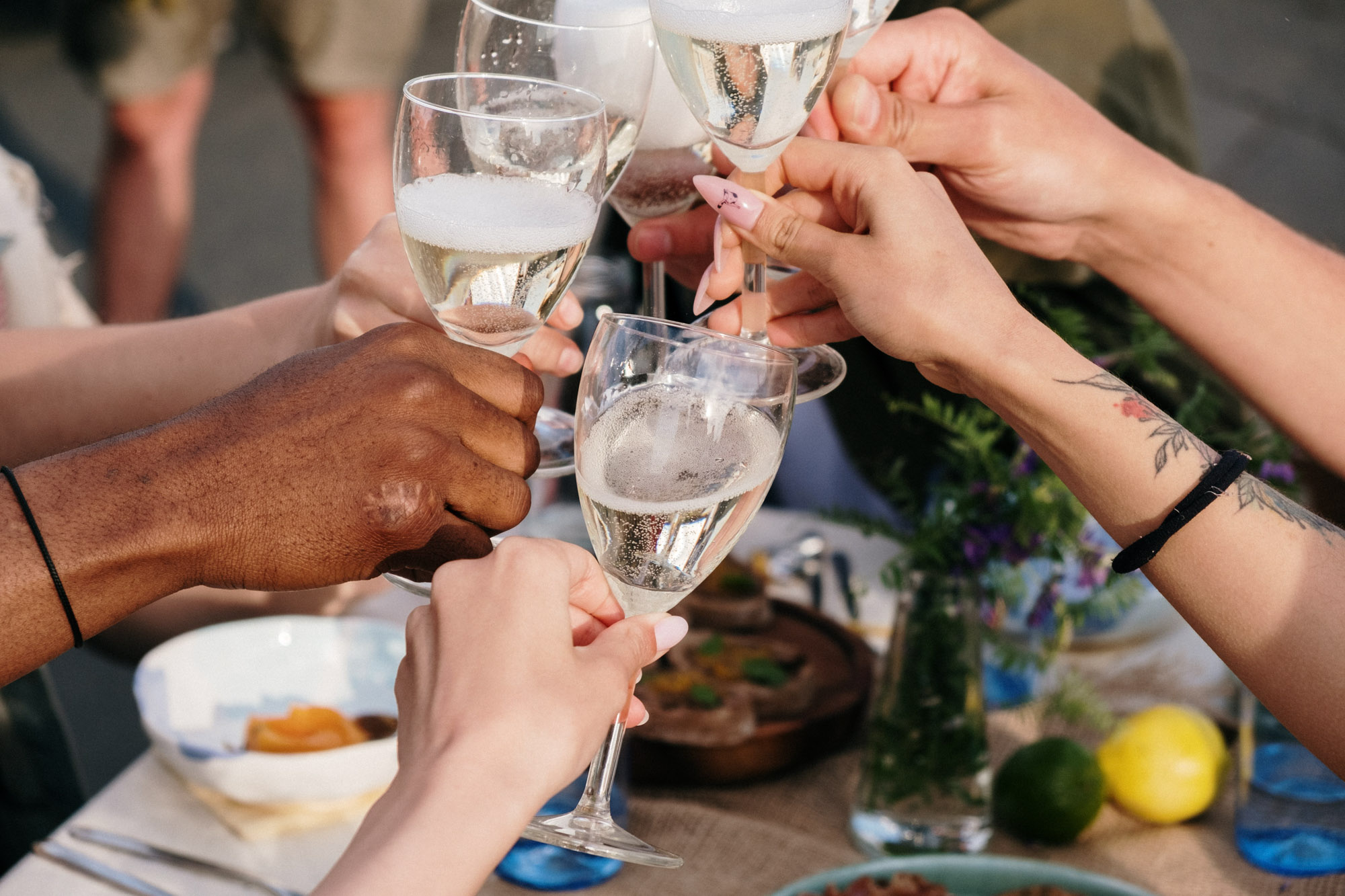 Friends enjoying a meal and raising a glass on a restaurant patio