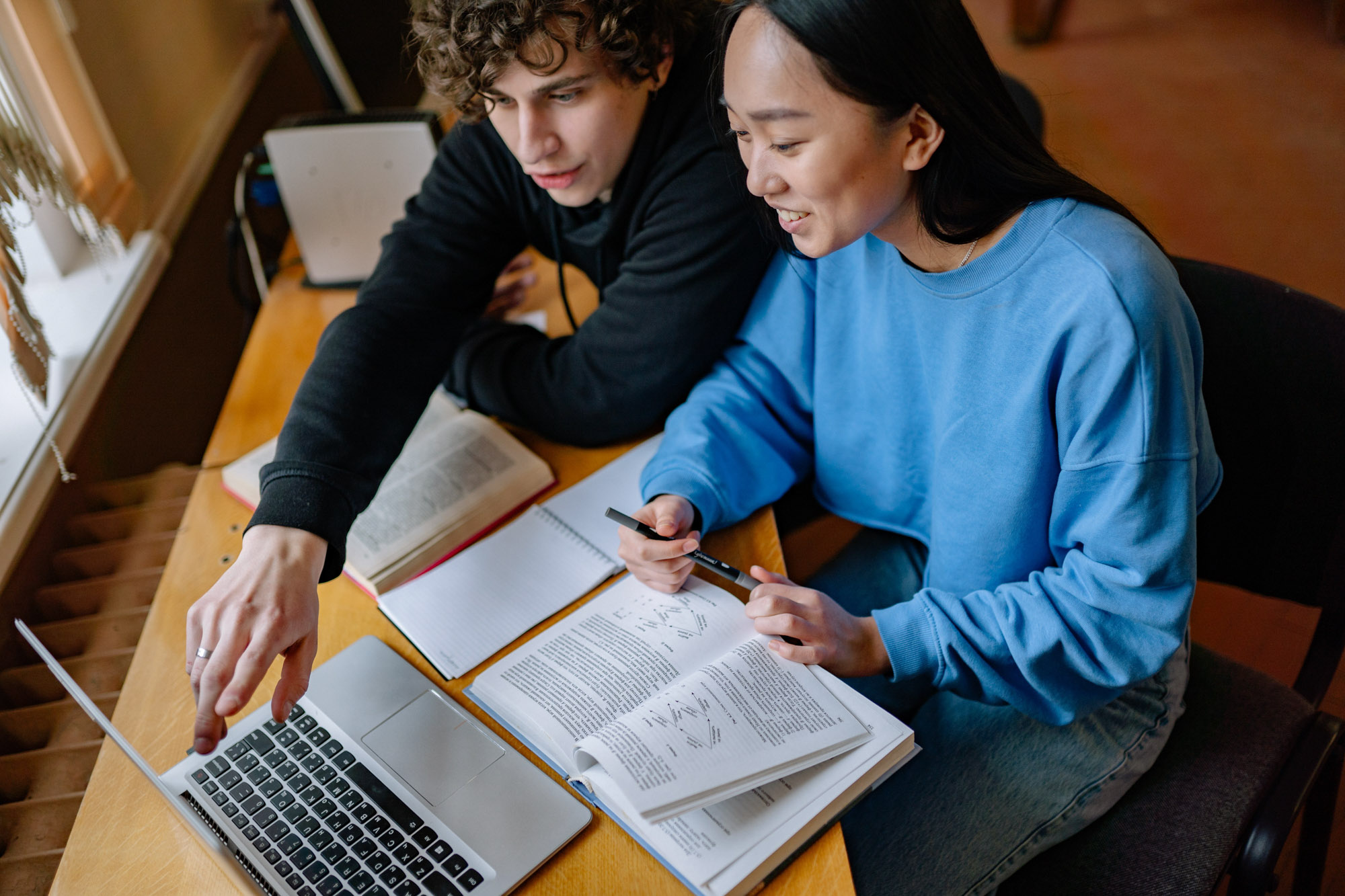 Two students studying together with a laptop