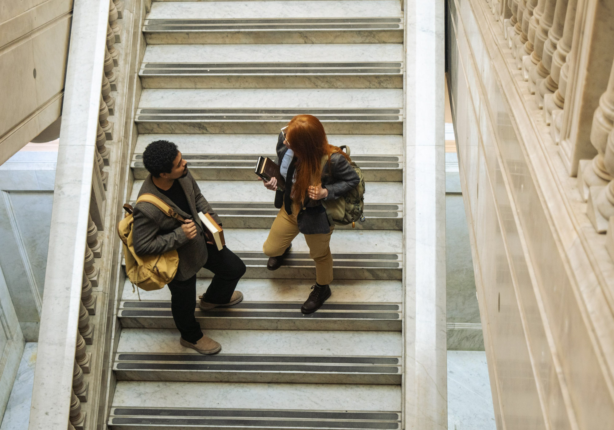 Two students talking on the stairs on campus