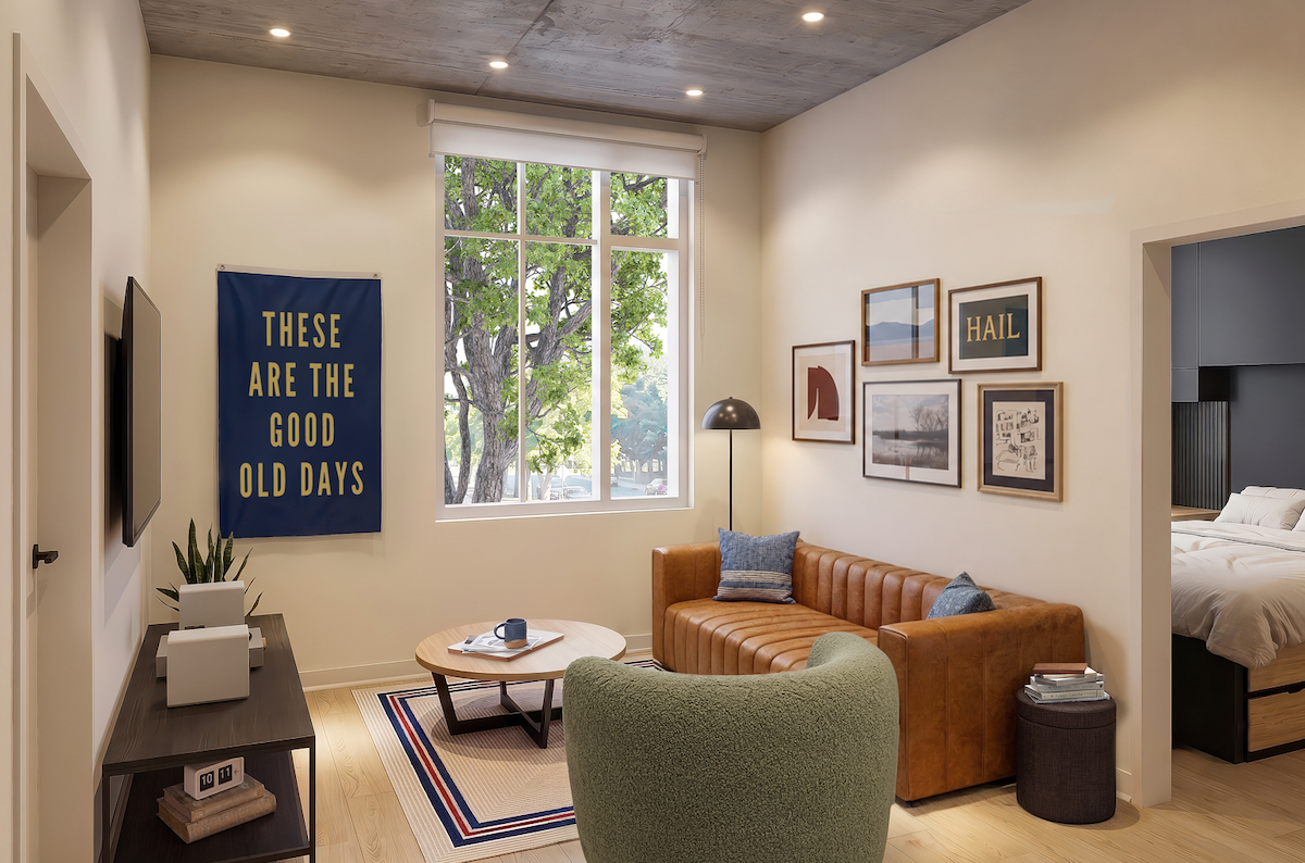 Bright modern apartment living room with a brown tufted sofa green accent armchair coffee table gallery wall and a view into the bedroom