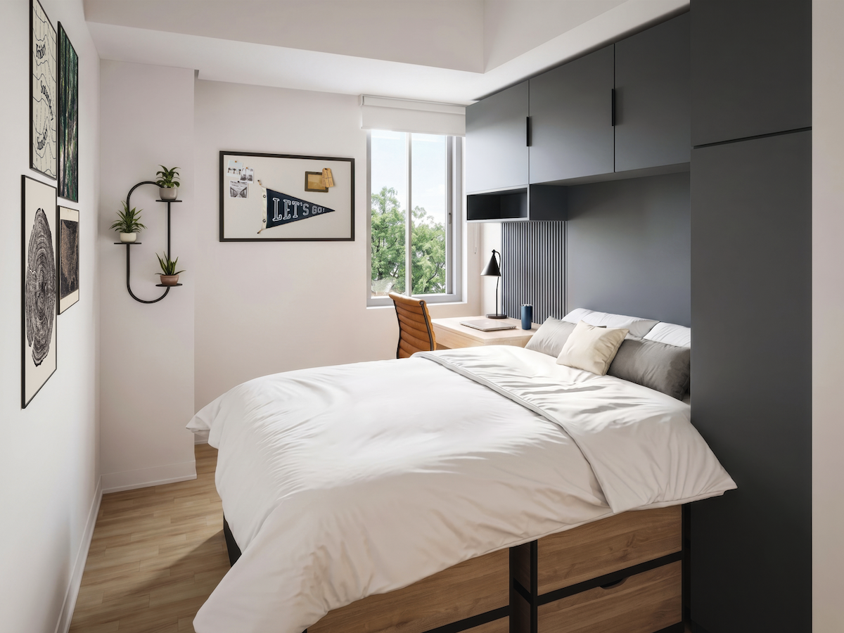 Modern studio bedroom featuring built in charcoal storage cabinets an under bed drawer unit and a dedicated desk workspace by the window